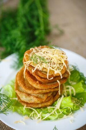 fried potato pancakes with cheese and herbsの写真素材