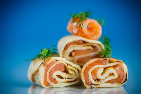small rolls of thin pancakes with salted red fish