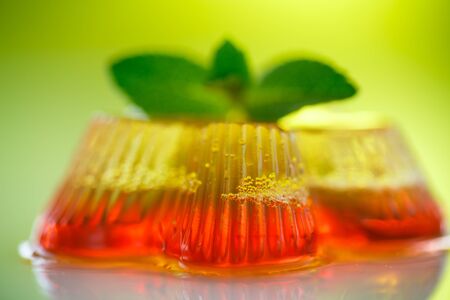 colorful fruit jelly sweets on a green backgroundの写真素材