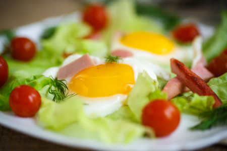 fried eggs with sausage and tomato on a plate