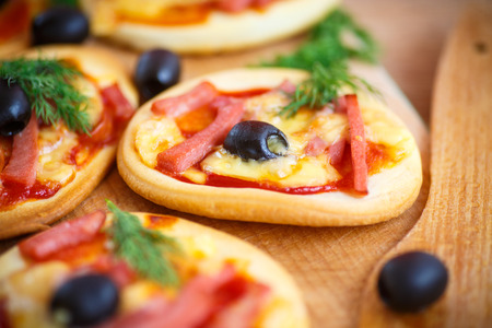 mini pizza with olives, bacon and cheeseの写真素材