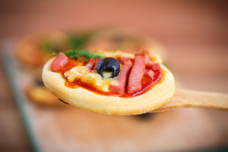 mini pizza with olives, bacon and cheeseの写真素材