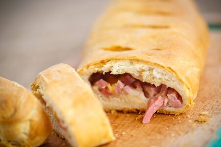 bread stuffed with cheese and bacon on a wooden boardの写真素材