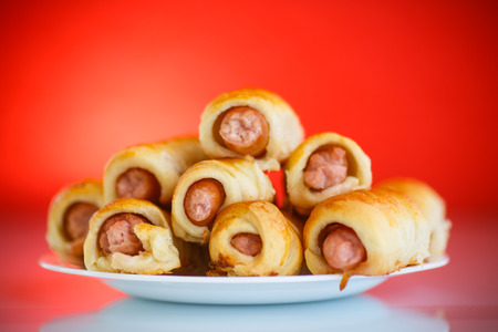 sausage baked in pastry on a red backgroundの写真素材
