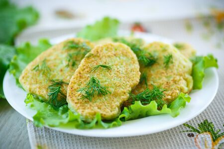 fried zucchini fritters with dill on a plateの写真素材