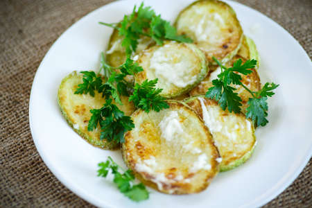 Fried zucchini with sauce on a white plateの写真素材