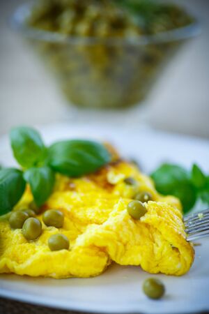 scrambled eggs with green peas on a plateの写真素材