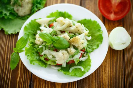 salad with cauliflower, tomatoes and herbs on a plateの写真素材