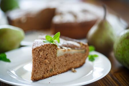 cake with pears in powdered sugar on a wooden tableの写真素材