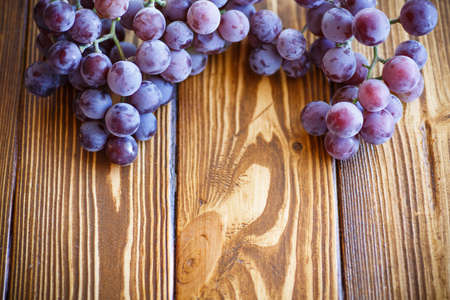 bunch of grapes on a wooden tableの写真素材