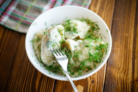 boiled dumplings with sour cream and dillの写真素材