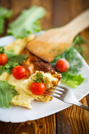 Omelette with tomatoes and lettuce on a plateの写真素材