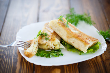 fried stuffed spring rolls on a plate with greens
