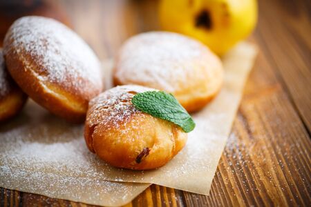 donuts with quince filling sprinkled with powdered sugarの写真素材