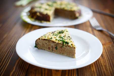 liver pie with cheese and herbs on a plate