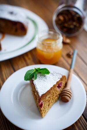 sweet honey cake with cherries in powdered sugarの写真素材