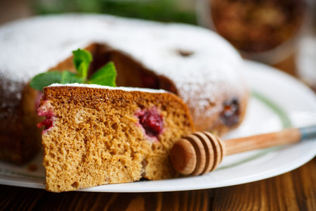 sweet honey cake with cherries in powdered sugar