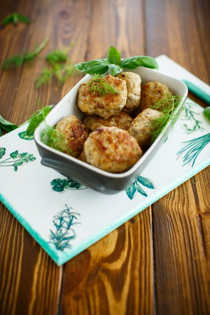 fried cutlet in ceramic form on a wooden tableの写真素材