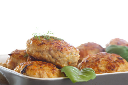 fried meatballs with herbs on white background