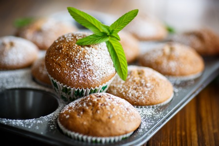sweet baked muffins with jam inside in powdered sugarの写真素材