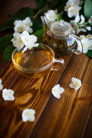 Jasmine tea in a glass pot on a wooden tableの写真素材