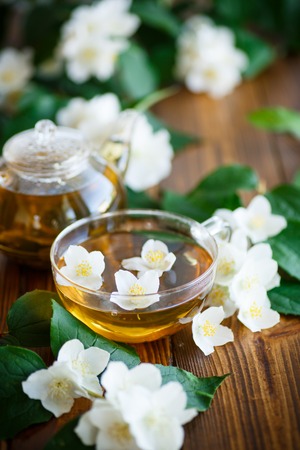 Jasmine tea in a glass pot on a wooden tableの写真素材