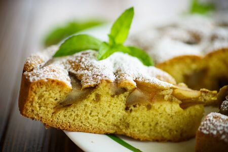cake with pears in powdered sugar on a wooden tableの写真素材