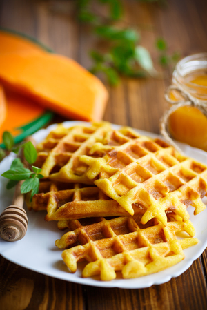 pumpkin waffles with honey on a wooden tableの写真素材