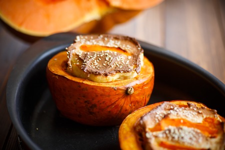 Pumpkin baked with cheese and sesame seeds on a baking sheetの写真素材