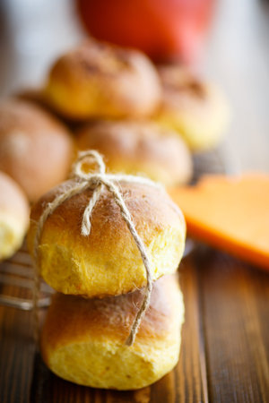 Pumpkin sweet buns on a wooden table