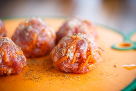 raw meatballs tangled meat with carrots and vegetablesの写真素材