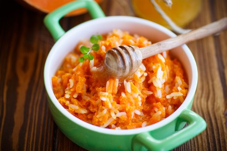 boiled pumpkin with rice and honey on a wooden tableの写真素材