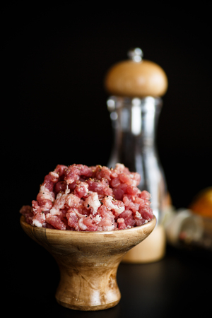 Chopped meat in a wooden bowl with spicesの写真素材