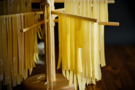 Home-made noodles are dried on a wooden standの写真素材
