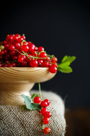 Ripe red currant in a wooden vase