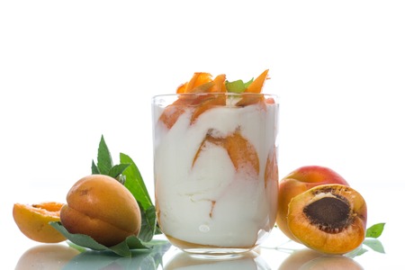 Sweet Greek yogurt with apricots on a white backgroundの写真素材