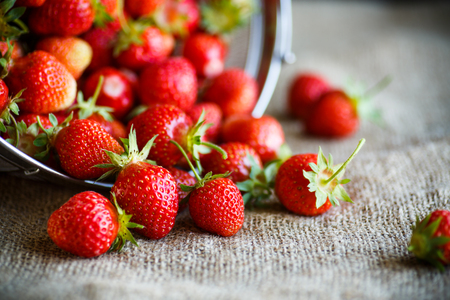 ripe red strawberry on a table with burlapの写真素材