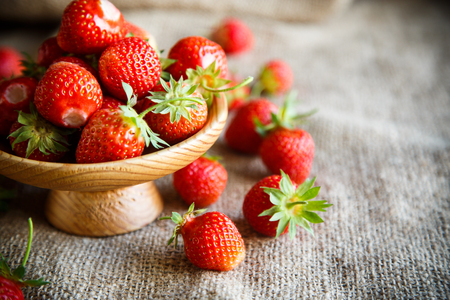 ripe red strawberry on a table with burlapの写真素材