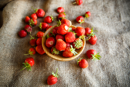 ripe red strawberry on a table with burlapの写真素材