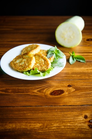 fried zucchini fritters on a wooden tableの写真素材
