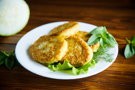 fried zucchini fritters on a wooden tableの写真素材