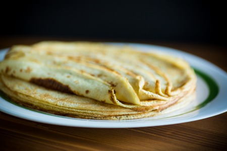 Thin pancakes stacked on a plate in a pileの写真素材