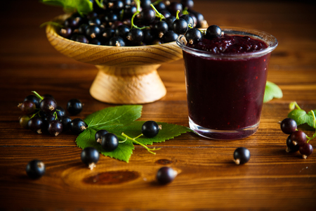 sweet jam of black currant berries on a wooden tableの写真素材