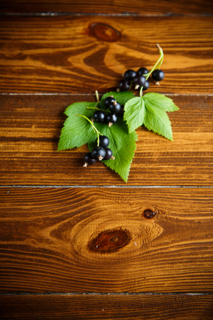 ripe raw berries black currants on a wooden tableの写真素材