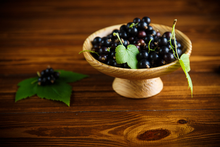 ripe raw berries black currants on a wooden tableの写真素材