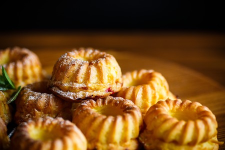 sweet muffin curd in sugar powder on the wooden tableの写真素材