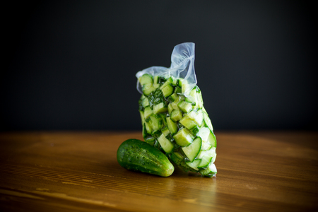 fresh sliced cucumbers in a vacuum package on a wooden tableの写真素材