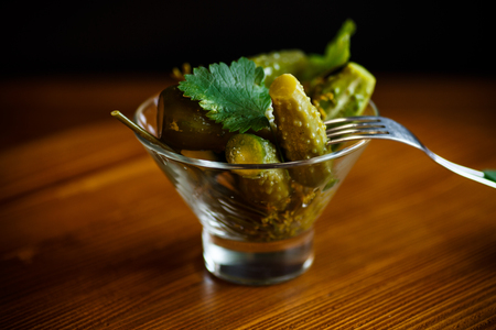 Pickled cucumbers with herbs and spices on a black backgroundの写真素材