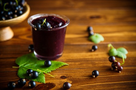 sweet jam of black currant berries on a wooden tableの写真素材