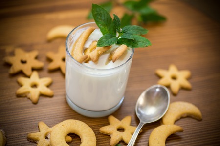 sweet homemade yogurt with cookies in a glass cup on a wooden tableの写真素材